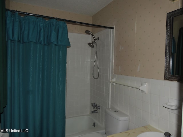 bathroom featuring toilet, tile walls, shower / bath combo, and a textured ceiling