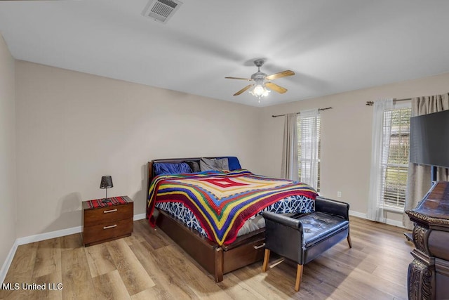 bedroom featuring light wood-style flooring, visible vents, and baseboards