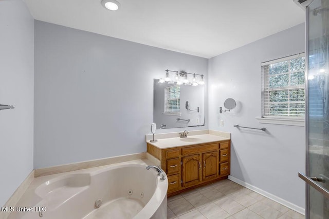 bathroom with a whirlpool tub, tile patterned flooring, vanity, and baseboards