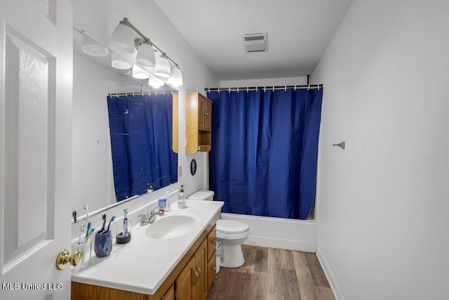 full bathroom featuring visible vents, toilet, shower / tub combo with curtain, wood finished floors, and vanity