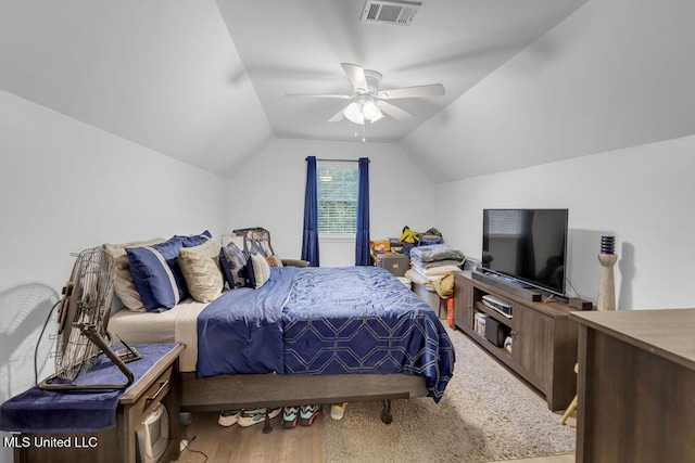 bedroom featuring wood finished floors, visible vents, vaulted ceiling, and ceiling fan