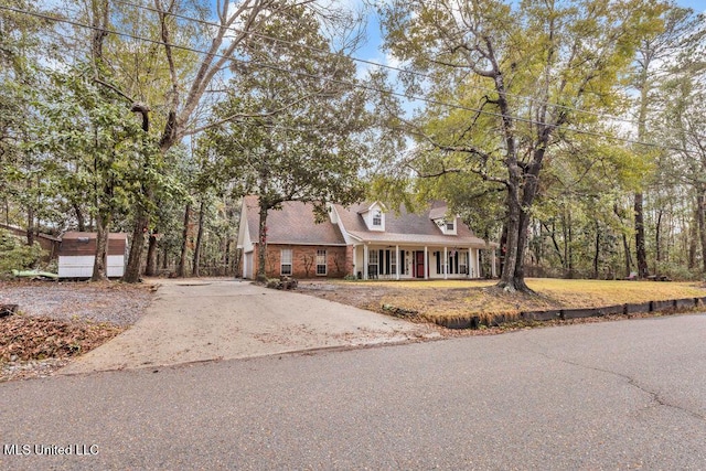 cape cod house featuring aphalt driveway and covered porch