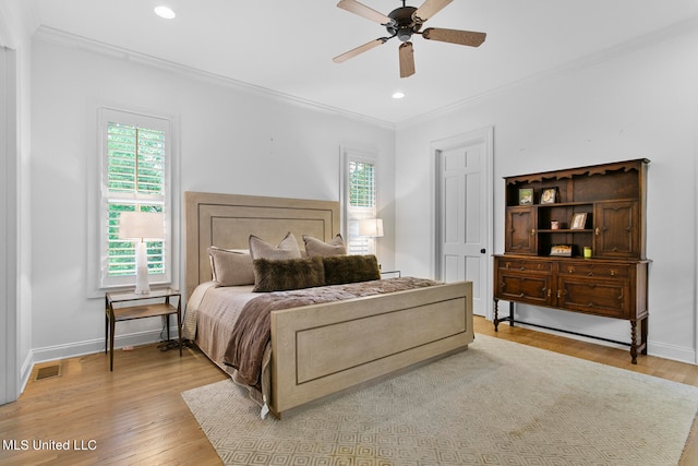 bedroom with light hardwood / wood-style floors, ornamental molding, and ceiling fan