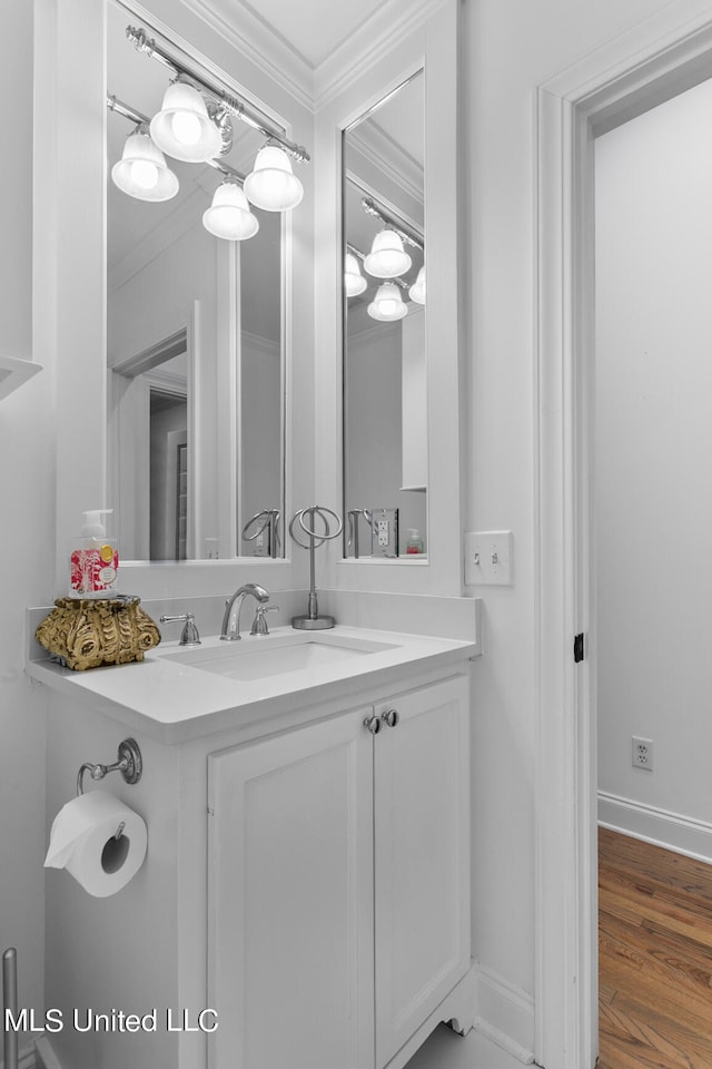 bathroom featuring vanity, crown molding, and wood-type flooring