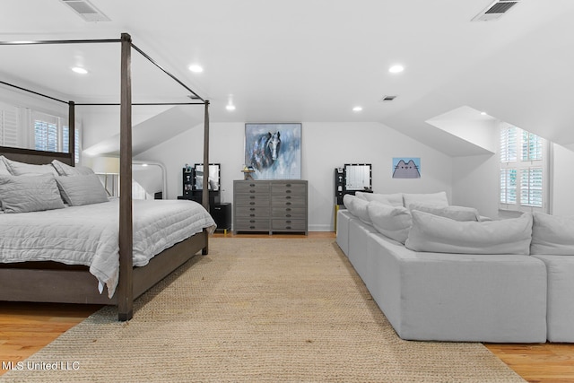 bedroom with vaulted ceiling and light hardwood / wood-style flooring