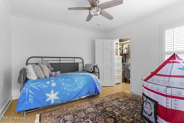 3844 Hawthorn Dr, Jackson, MS 39216 - bedroom featuring wood finished floors, ornamental molding, ceiling fan, a walk in closet, and baseboards