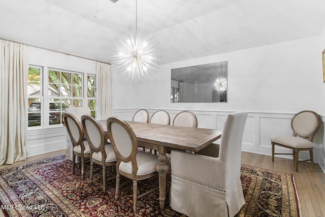 3844 Hawthorn Dr, Jackson, MS 39216 - dining area featuring a notable chandelier, a decorative wall, wood-type flooring, and wainscoting