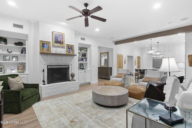 3844 Hawthorn Dr, Jackson, MS 39216 - living area with a brick fireplace, ceiling fan with notable chandelier, visible vents, and built in features