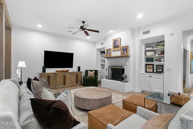 living room with light hardwood / wood-style floors, ceiling fan, a fireplace, and built in shelves