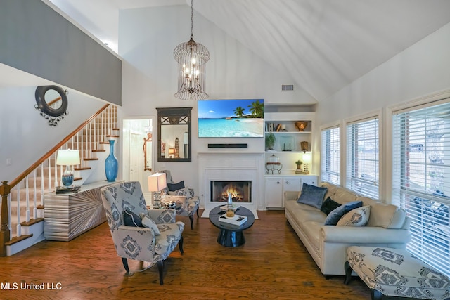 living room featuring dark hardwood / wood-style floors, a towering ceiling, and a chandelier