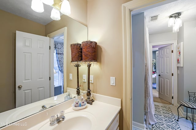 bathroom with a textured ceiling and vanity