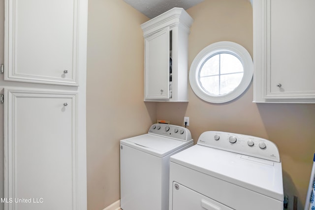 laundry room featuring cabinets and washer and clothes dryer