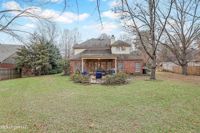 back of property with a lawn and a patio area