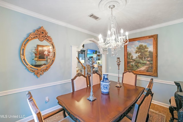 dining room with ornamental molding and a chandelier