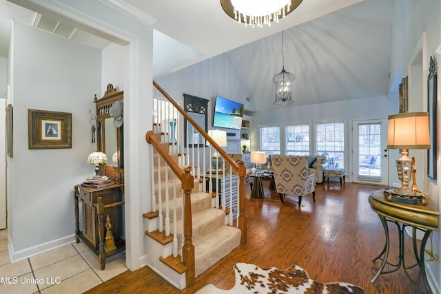 stairs featuring a chandelier, a towering ceiling, and hardwood / wood-style flooring