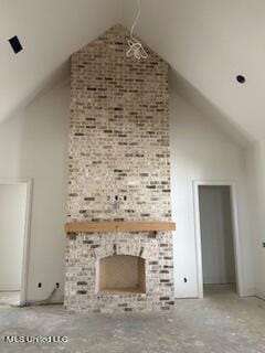 bonus room featuring high vaulted ceiling and a stone fireplace