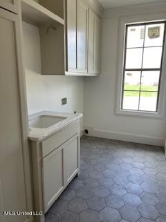 laundry area with cabinets and sink