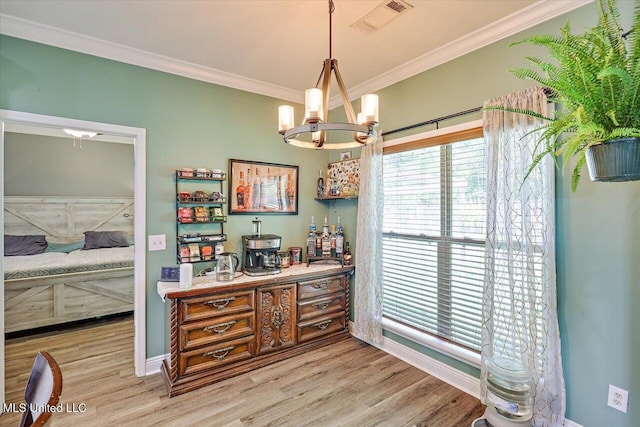 interior space featuring crown molding, a chandelier, and light wood-style flooring