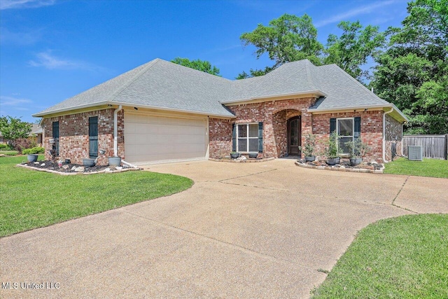 ranch-style house featuring fence, a shingled roof, brick siding, a garage, and a front yard