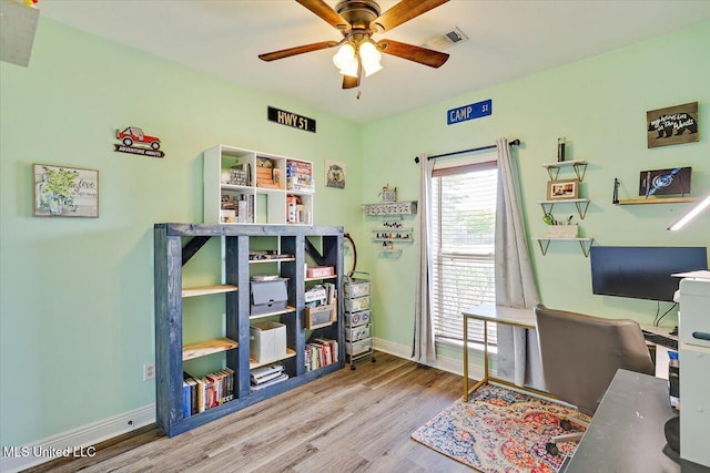 office area with baseboards, a ceiling fan, wood finished floors, and visible vents