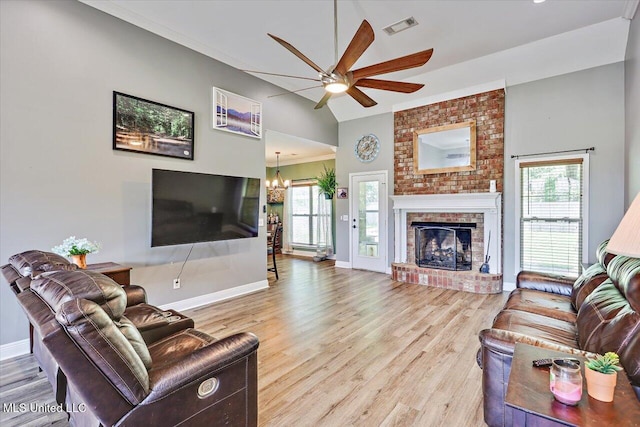 living area with baseboards, visible vents, plenty of natural light, and ceiling fan with notable chandelier