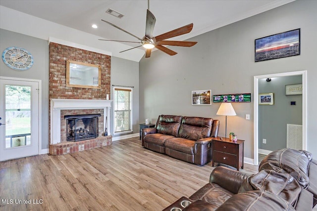 living area featuring a healthy amount of sunlight, a ceiling fan, wood finished floors, and visible vents