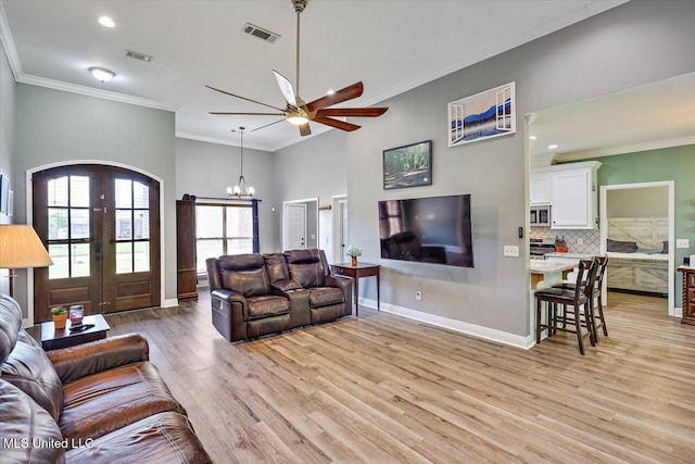 living room with crown molding, visible vents, french doors, and light wood finished floors
