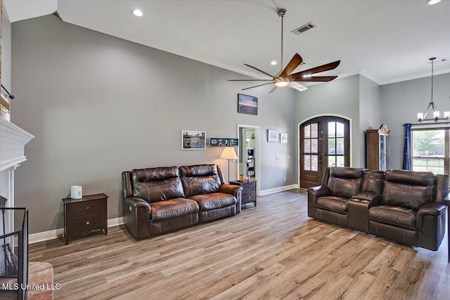 living area featuring visible vents, baseboards, recessed lighting, arched walkways, and ceiling fan with notable chandelier