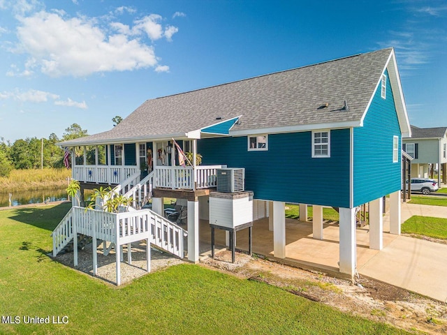 11162 New York St, Bay Saint Louis, MS 39520 - rear view of house with a carport, roof with shingles, central air condition unit, stairs, and a lawn