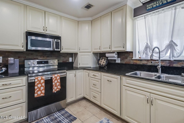 11162 New York St, Bay Saint Louis, MS 39520 - kitchen featuring stainless steel appliances, a sink, light tile patterned floors, and backsplash