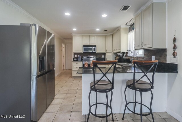 11162 New York St, Bay Saint Louis, MS 39520 - kitchen featuring appliances with stainless steel finishes, a peninsula, a sink, decorative backsplash, and recessed lighting