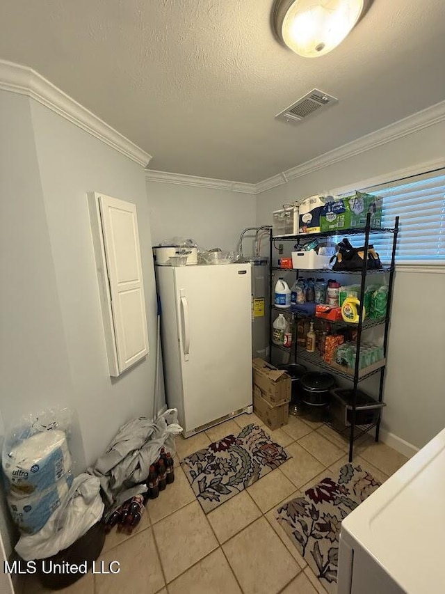 11162 New York St, Bay Saint Louis, MS 39520 - laundry room featuring washer / dryer, crown molding, light tile patterned floors, and a textured ceiling
