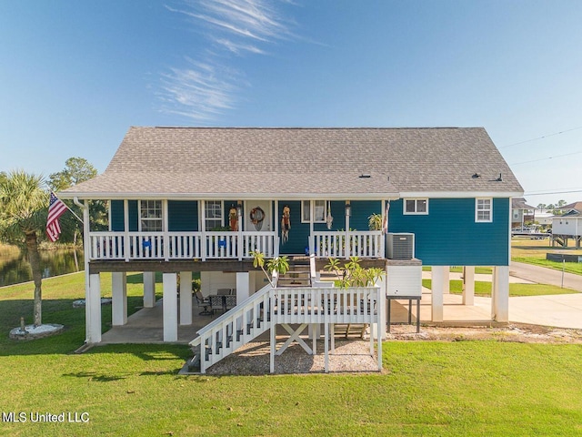 11162 New York St, Bay Saint Louis, MS 39520 - beach home with a carport, concrete driveway, roof with shingles, and a front lawn
