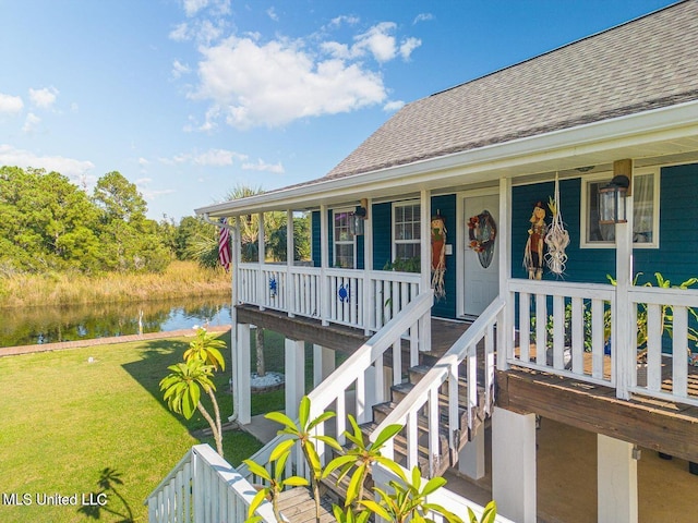 11162 New York St, Bay Saint Louis, MS 39520 - doorway to property with roof with shingles, a water view, covered porch, and a yard