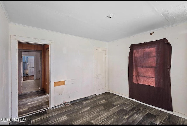 empty room featuring dark hardwood / wood-style floors and crown molding