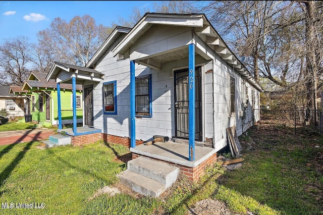 view of front of home featuring fence and a front lawn