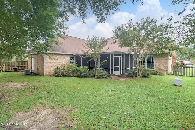 back of house with a sunroom, central AC, and a lawn