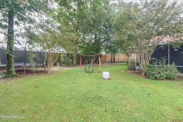 view of yard with a sunroom and a trampoline