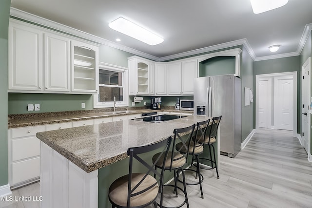 kitchen featuring white cabinets, a center island, dark stone counters, and appliances with stainless steel finishes