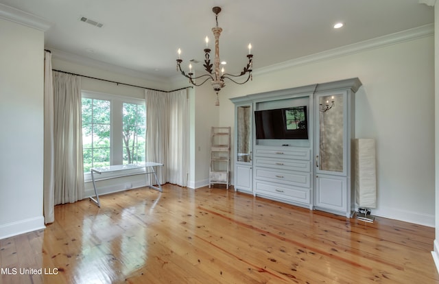 unfurnished dining area featuring a notable chandelier, ornamental molding, and light wood-type flooring