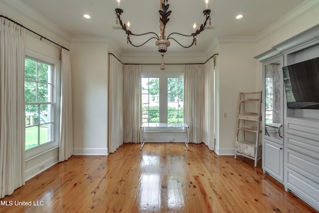 unfurnished dining area featuring crown molding, a healthy amount of sunlight, and light hardwood / wood-style flooring