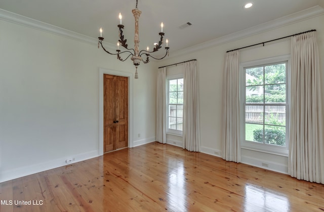 empty room featuring light hardwood / wood-style floors, crown molding, and an inviting chandelier