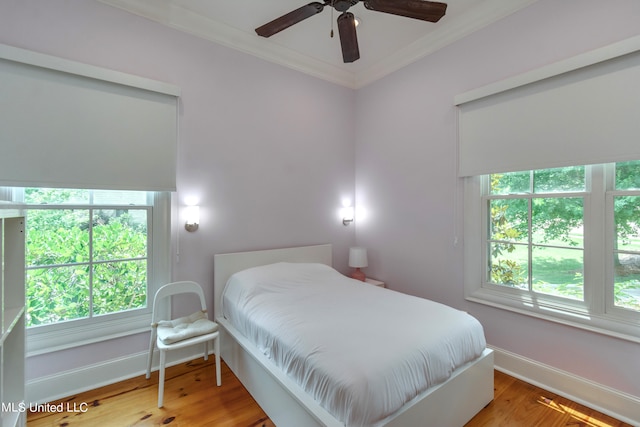 bedroom with ceiling fan, ornamental molding, and light wood-type flooring