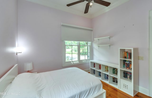 bedroom with hardwood / wood-style floors, crown molding, and ceiling fan