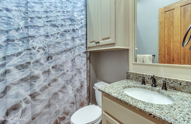 bathroom featuring vanity, toilet, and walk in shower