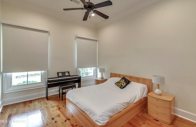 bedroom with ceiling fan, ornamental molding, and light hardwood / wood-style flooring