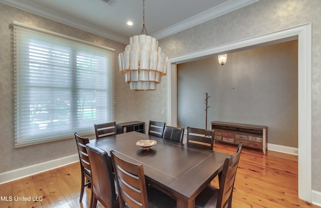 dining room with light hardwood / wood-style floors, ornamental molding, and plenty of natural light