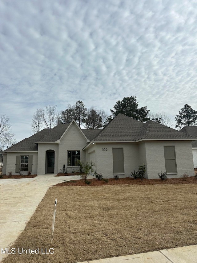 ranch-style home featuring a front lawn and a garage