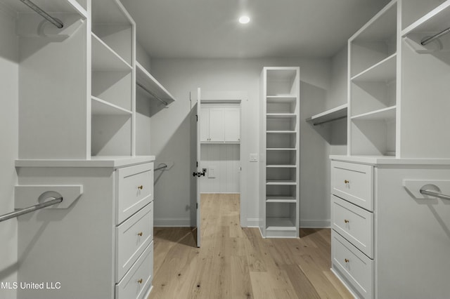 walk in closet with light hardwood / wood-style flooring