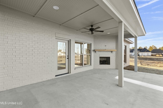 view of patio / terrace featuring an outdoor brick fireplace and ceiling fan